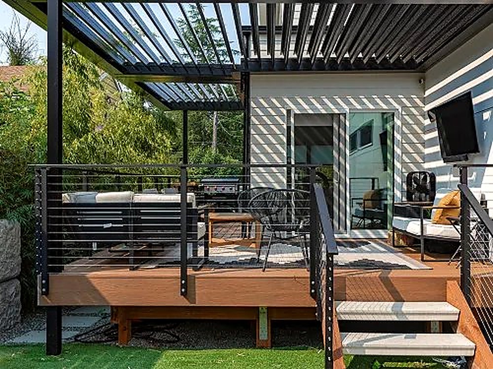 Pergola attached to a house over a composite deck with cable railing